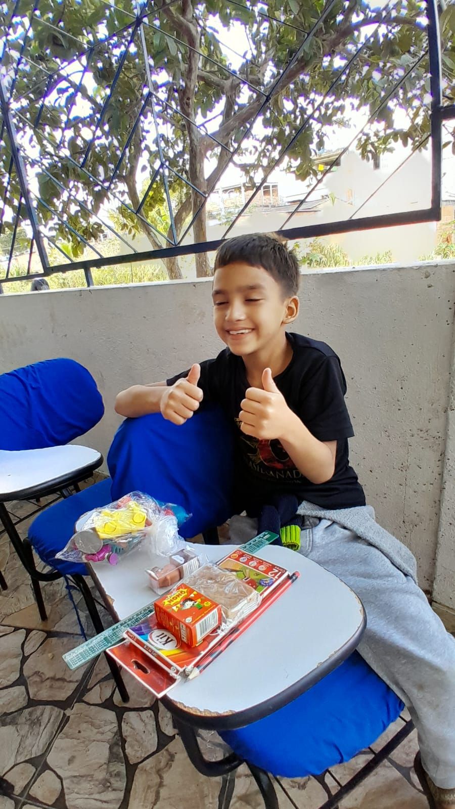 Menino do Instituto com o material que trocou por méritus